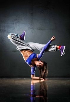 a man doing a handstand on the floor in front of a black background