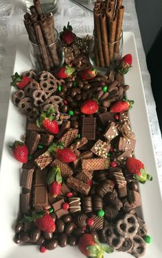 a white plate topped with chocolate covered strawberries and pretzel treats on top of a table