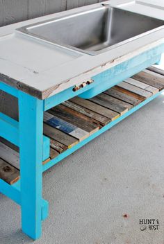 an old wooden table with a metal sink on it's top and some wood planks underneath