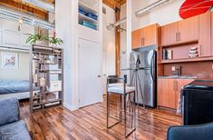 a kitchen and living room with wood floors in a loft style apartment at the edge of a city street