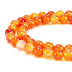 an orange and white beaded bracelet on a white background