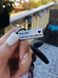 someone is holding up a fake ring that says drive safe, i need you here with me