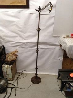 a floor lamp is standing in front of a white wall and some other items on the floor