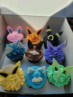 a box filled with lots of cupcakes covered in frosting and decorated like animals