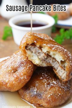 sausage pancake bites on a white plate with dipping sauce in the background and text overlay that reads, sausage pancake bites