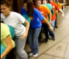 a group of people standing next to each other in front of a wall with balloons on it