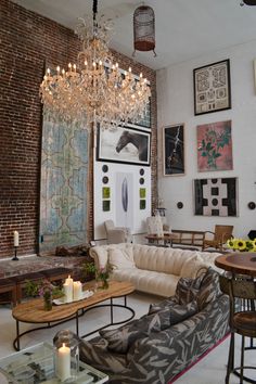 a living room filled with furniture and a chandelier hanging over it's head