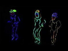 three neon colored figures in the dark