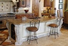 a large kitchen with an island in the middle and three stools at the end