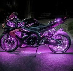 two motorcycles parked next to each other on the street in front of a building at night