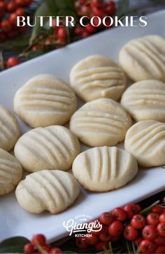 butter cookies on a white platter surrounded by red berries and greenery with text overlay