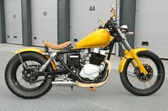 a yellow motorcycle parked in front of a garage