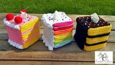 three different colored cakes sitting on top of a wooden table