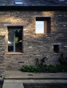 an exterior view of a house with stone walls and windows