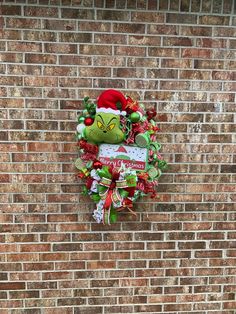 a christmas wreath hanging on the side of a brick wall with an angry grin face