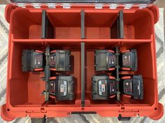 a red toolbox filled with lots of black and decker power drillers on top of a carpeted floor