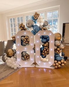 a large number sign with balloons in the shape of letters and numbers that spell out the word 100