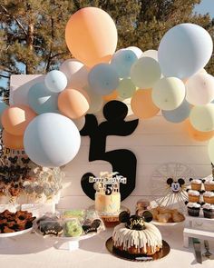 a table topped with lots of desserts and balloons