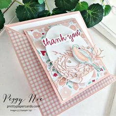 a close up of a thank you card on a table next to a potted plant