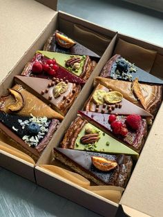 an open box filled with assorted desserts on top of a table