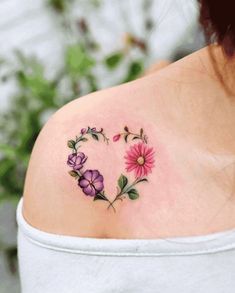 a woman's shoulder with flowers in the shape of a heart