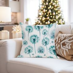 a living room with a christmas tree in the background and a couch with pillows on it