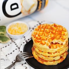 a stack of waffles sitting on top of a black plate with a fork