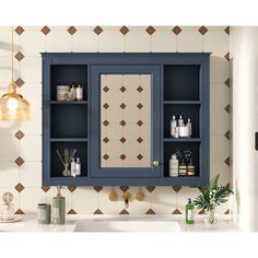 a bathroom with a sink, mirror and blue cabinet in front of a tiled wall