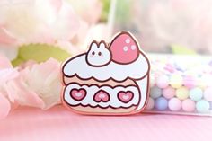 a pink and white cake pin sitting on top of a table next to some candy