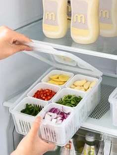 a refrigerator door is open with food in containers and someone reaching into the freezer