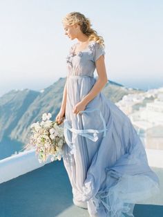 a woman in a long dress holding a bouquet