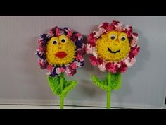 two crocheted flowers with faces on them