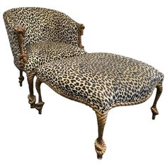 a leopard print chaise lounge chair with wooden legs