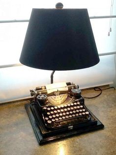 an old fashioned typewriter lamp sitting on the floor