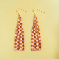 two pairs of orange and pink beaded earrings hanging from gold - tone earwires