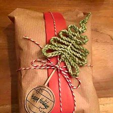 a wrapped present with a red ribbon tied around it and a tag on the top