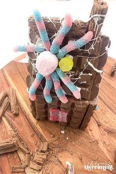 a close up of a toy made out of chocolate and marshmallows on a wooden table