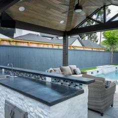 an outdoor kitchen next to a swimming pool