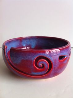 a red and blue bowl sitting on top of a white counter next to a wall