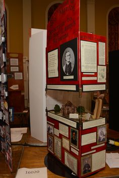 an old fashioned red and white display case with pictures on the front, in a museum setting