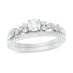 a white gold ring set with diamonds on the band and an engagement ring in the middle