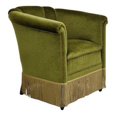 a green chair with fringe trim around the arm and back, on a white background