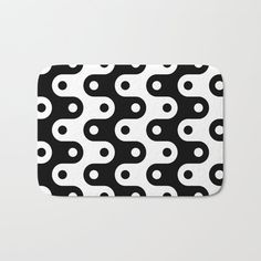 a black and white bath mat with an abstract design in the shape of two circles