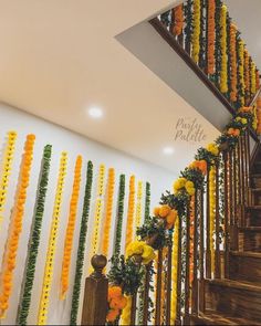 the stairs are decorated with flowers and garlands for an event or wedding reception in orange, yellow and green colors