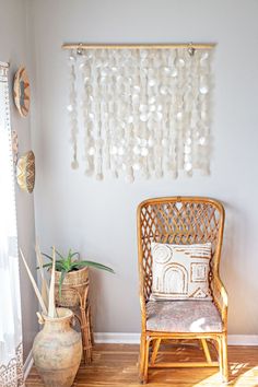 a wicker chair sitting in front of a window next to a potted plant