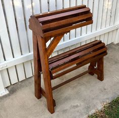 a wooden bench sitting next to a white fence