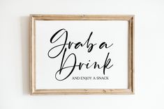 a framed sign that says graba drink and enjoy a snack on the wall above it