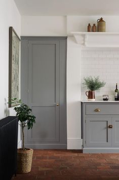 a kitchen with gray cabinets and white walls