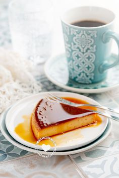 a piece of cake on a plate with syrup and a cup of coffee in the background