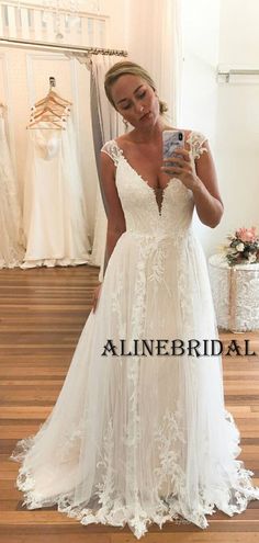 a woman in a wedding dress taking a selfie with her cell phone while looking into the mirror